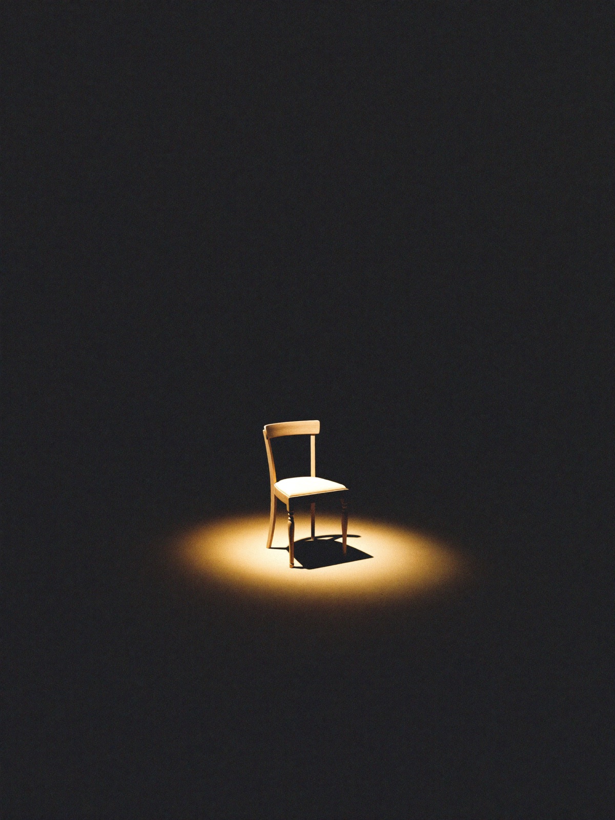 An empty chair in a warm spotlight